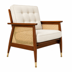 A mid-century modern accent chair featuring a warm brown wooden frame, natural cane back and side panels, and cream-colored tufted cushions, shown on a solid white background.